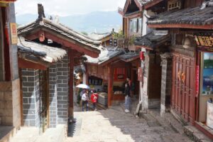 a group of people walking down a street next to tall buildings