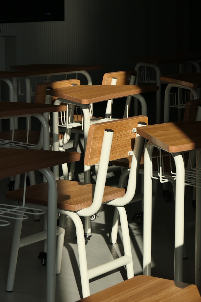A room filled with lots of wooden desks and chairs