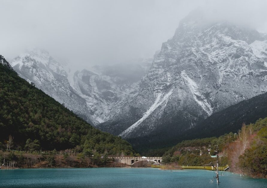 reflection of mountains and trees on body of water